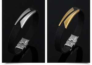 Detail of silver and gold brushed stainless steel clasps on black silicone bracelets