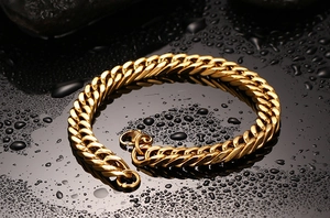Men's polished gold Cuban link stainless steel bracelet on water droplet background