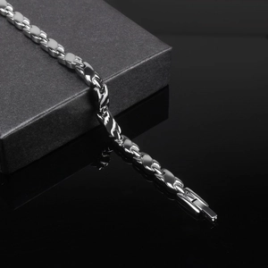Nahaufnahme eines silbernen Magnetarmbands mit geometrischen Gliedern auf Schmuckdose
