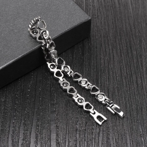 Silver hollow heart bracelet with rhinestones and black magnets on jewelry box