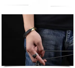 Detail view of a men's black rubber bracelet with gold accents and vintage rings