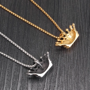 Golden and silver hip-hop crown pendant necklaces on dark wood background
