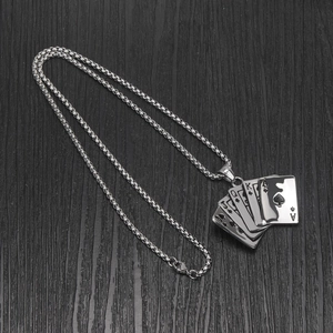 Macro detail of silver poker royal flush pendant on box chain with black wood background