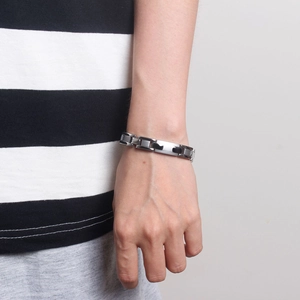 Bracciale magnetico da uomo in acciaio argento e nero indossato al polso, stile moderno