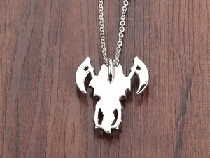 Detailed view of silver stainless steel gothic reaper scythe pendant on wood background
