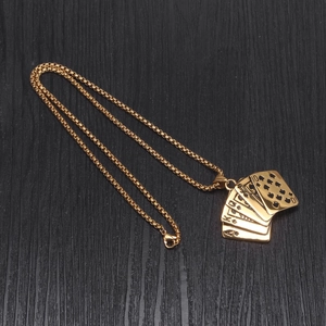 Detailed close-up of golden titanium royal flush poker pendant on a black wood background