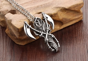 Macro detail of gothic grim reaper pendant with double scythes on stainless steel chain