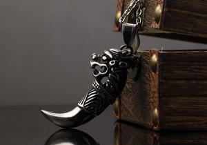 Makroaufnahme des Vintage-Edelstahl-Wolfszahnanhängers mit Stammesgravuren und Kette