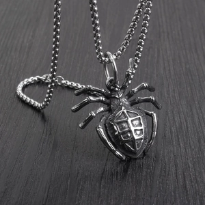 Vintage silver spider pendant with square bead chain on a dark wood background