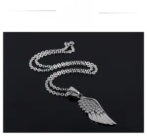 Detailed macro view of vintage silver angel wing pendant with intricate feather textures