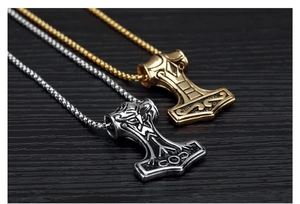 Detail of Mjölnir pendant with intricate Viking totems on dark wooden background
