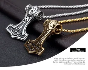 Close-up of Mjölnir pendants in vintage gold and black silver on a leather background