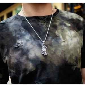 Détail du pendentif mains en prière vintage avec relief de croix et chaîne argentée