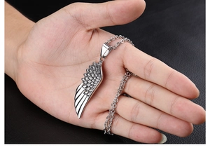 Detailed close-up of retro silver wing pendant showing clear feather textures on chain