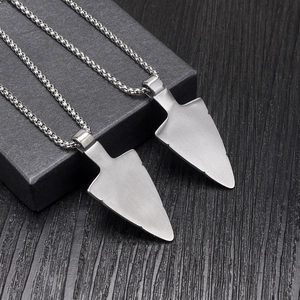 Detailed macro of two matte silver steel spearhead pendants on sleek box chains