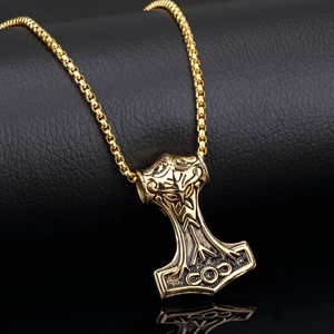 Pendentif Marteau de Thor doré avec gravures fines sur un fond noir élégant