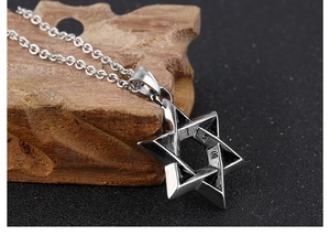 Close-up of vintage stainless steel Star of David pendant with polished and aged finish