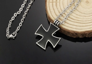 Detail of black enamel iron cross pendant with silver trim on a stainless steel chain