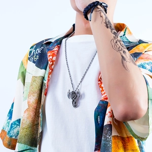 Cool stainless steel grim reaper scythe pendant necklace worn by a male model on street style