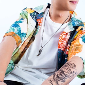 Retro Wolfszahn-Anhänger aus Edelstahl an männlichem Model im Streetwear-Look