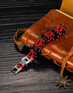 Gros plan du bracelet chaîne de moto en acier inoxydable rouge et noir sur du cuir