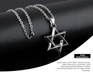 Close-up of titanium steel hexagram pendant with engraved mantra on black background
