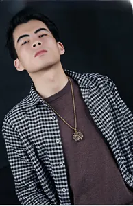 Detailed macro view of a 3D gold tiger head pendant necklace worn by a male model