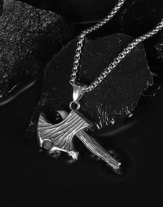 Vue détaillée du pendentif hache de combat avec texture de bois sur roche noire