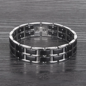 Bracelet homme large en acier inoxydable et céramique noire sur fond en bois sombre