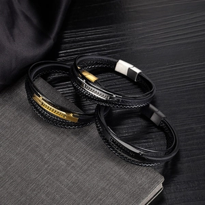 Dettaglio di bracciali multistrato in pelle intrecciata con chiusure in metallo oro e argento