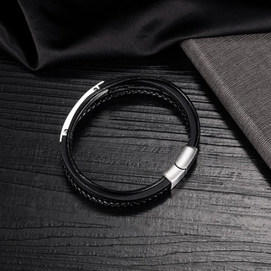 Dettaglio del bracciale multistrato in pelle intrecciata nera con chiusura in metallo