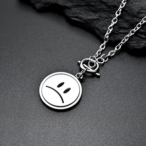 Collier rotatif en acier avec pendentif visage triste et fermoir OT de style minimaliste