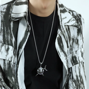 Close-up of a silver shark pendant on a box chain for men with street style apparel
