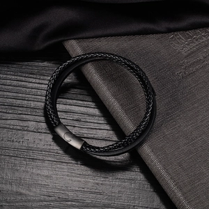 Dettaglio del bracciale in pelle intrecciata multistrato con chiusura in metallo nero opaco