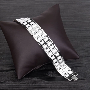 Détail des maillons en céramique blanche et des nœuds magnétiques sur un bracelet argent