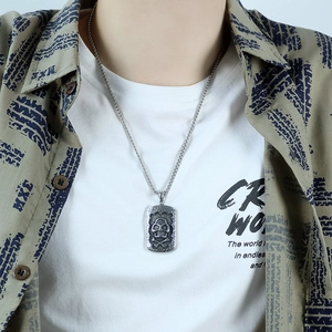 Gros plan du collier vintage avec pendentif tête de mort porté sur une chemise d'homme