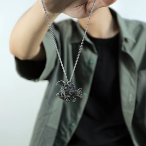 Dettaglio di una collana con ciondolo a forma di rana pescatrice in stile punk retrò