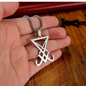 Gros plan du collier avec pendentif Sceau de Lucifer en acier sur fond en bois