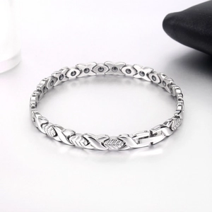 Macro detail of silver steel X-link leaf magnetic bracelet with polished therapy stones