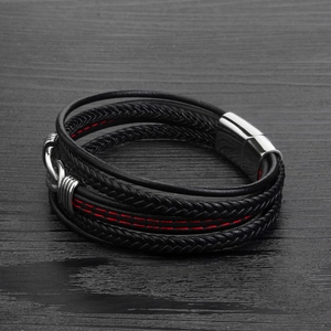 Détail macro du bracelet homme en cuir tressé noir multicouche avec fermoir magnétique