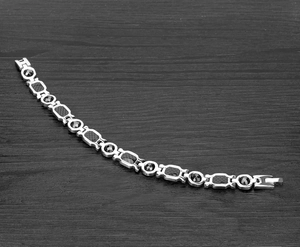 Detail of silver mens magnetic bracelet with carbon fiber texture and rotating beads