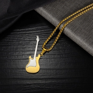 Macro detail of bicolored stainless steel guitar pendant on golden box chain