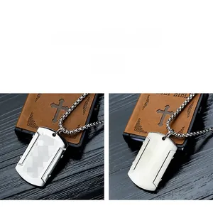 Pendentif plaque militaire en acier brossé avec chaîne perlée sur livre en cuir vintage