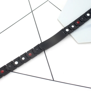 Detail of matte black magnetic therapy bracelet with inset health stones and ID plate