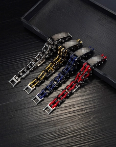 Détail de quatre bracelets chaîne de moto industriels en argent, or, bleu et rouge