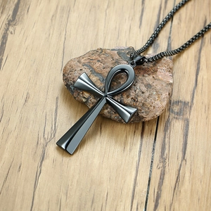 Detailed macro view of black stainless steel Ankh cross pendant on natural stone base