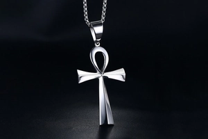 Macro shot of polished silver stainless steel Ankh cross pendant on a black background