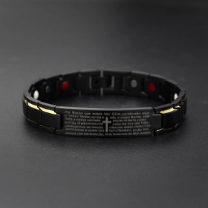 Macro view of black and gold health magnetic bracelet with engraved Lord's Prayer