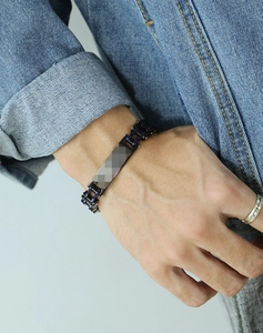 Gros plan d'un bracelet de moto vintage en acier inoxydable pour homme au poignet