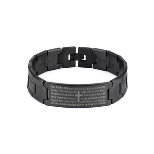 Macro shot of black stainless steel bracelet with engraved cross and Lord's Prayer text
